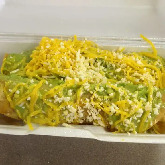 Wet burrito covered with green sauce cheese and crema