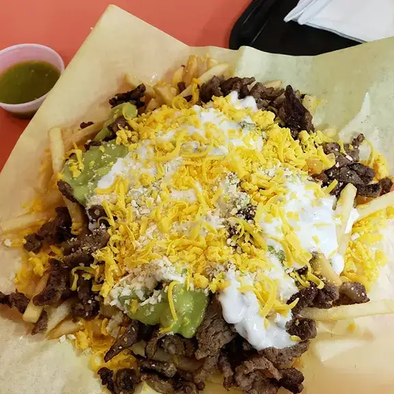 Carne asada fries topped with cheese guacamole and sour cream
