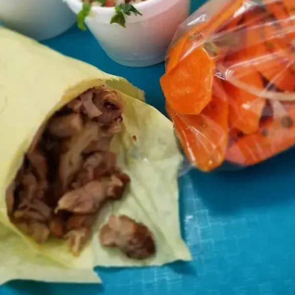Soft taco with grilled meat and fresh toppings wrapped in tortilla