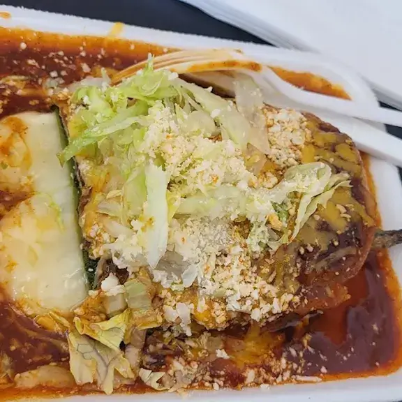 Enchiladas topped with red sauce cheese and lettuce